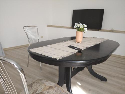 a black table with a vase of flowers on it at Wohnung am Bahnhof in Schmalkalden