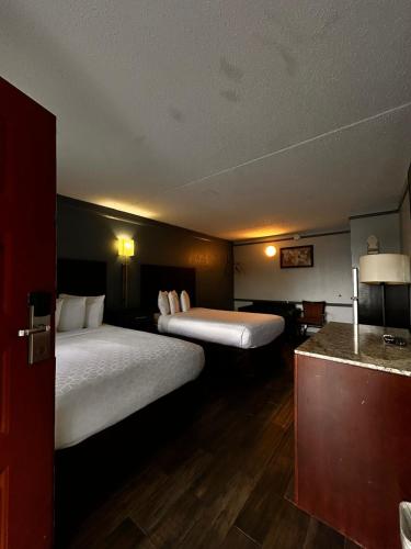 a hotel room with two beds and a counter at Capital O Kings Inn in Memphis