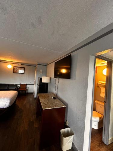 a hotel room with a bed and a desk in a room at Capital O Kings Inn in Memphis