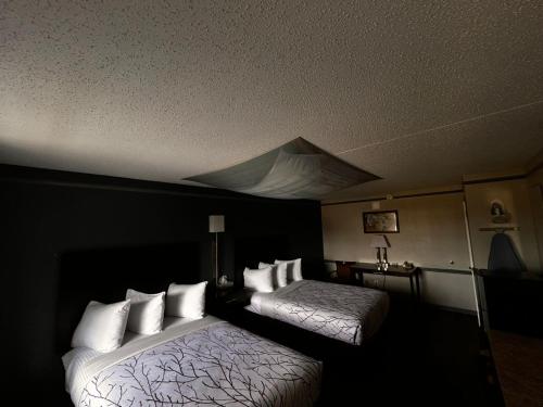 a hotel room with two beds with white pillows at Capital O Kings Inn in Memphis