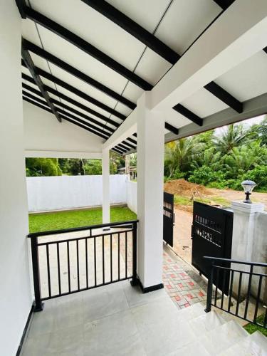 a white porch with a black and white railing at Himeth's Residence in Weliweriya