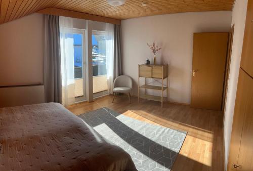 a bedroom with a bed and a desk and a window at Schwarzwald Apartments III in Lenzkirch