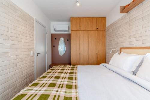 a bedroom with a bed with a green and white blanket at GO Rio Branco by LikeHome in Porto Alegre