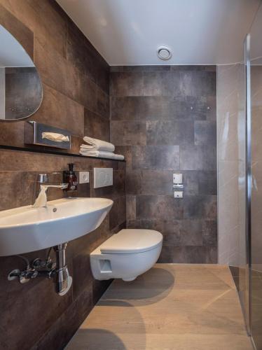 a bathroom with a toilet and a sink at Fletcher Hotel-Restaurant De Kempen in Reusel