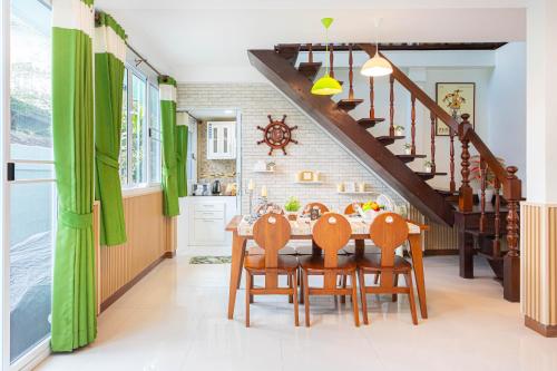 a kitchen with a dining room table with green curtains at Friend House BKK in Bangkok