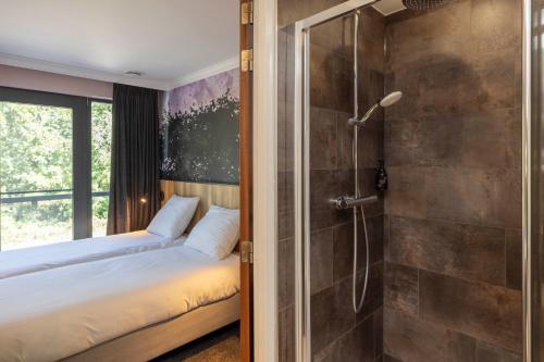 a bedroom with a bed and a shower at Fletcher Hotel-Restaurant De Kempen in Reusel