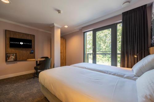 a hotel room with two beds and a window at Fletcher Hotel-Restaurant De Kempen in Reusel