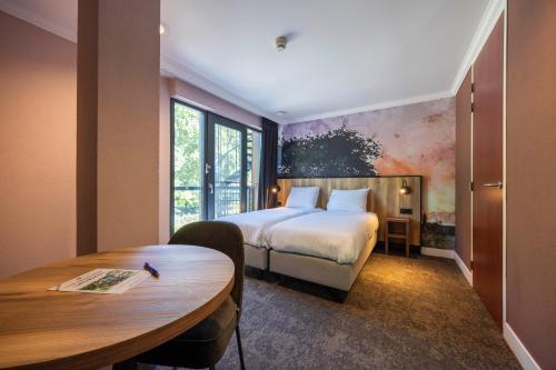a hotel room with a bed and a table at Fletcher Hotel-Restaurant De Kempen in Reusel