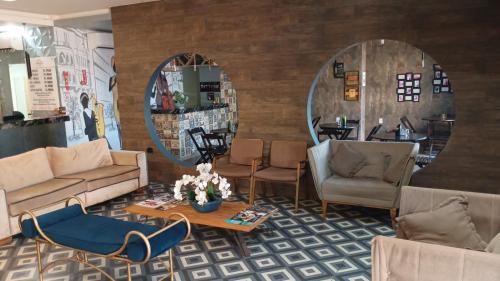 a living room with a couch and chairs and a table at INACIO'S PLAZA HOTEL in Marabá