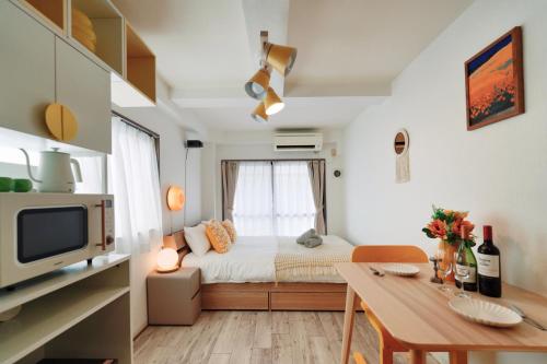 a small bedroom with a bed and a table and a tv at Home Story in Tokyo KANAMETYOU&Ikebukuro-Ginnzaまで直通&東京屋語 in Tokyo