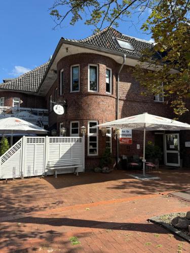 a brick house with an umbrella in front of it at Hotel Deutsches Haus in Löningen