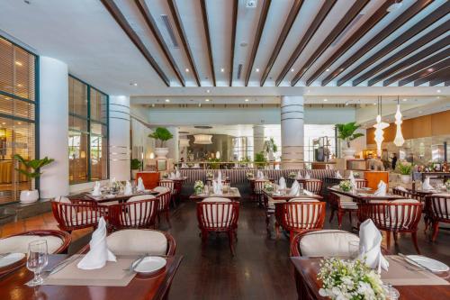 a dining room with tables and chairs in a restaurant at Garden Plaza Saigon - Formerly PARKROYAL Saigon in Ho Chi Minh City