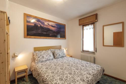 a bedroom with a bed and a picture on the wall at Dolomitihouse AUNER in Fiera di Primiero