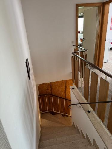 a staircase with white walls and wooden floors at MonteurGut Apartments Eiche in Lindern