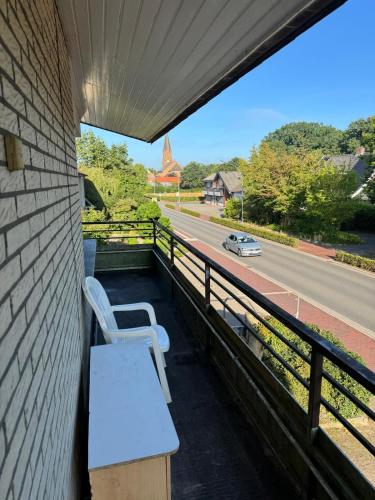 a balcony with two white chairs and a road at MonteurGut Apartments Eiche in Lindern