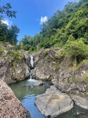 una cascada en el lateral de una montaña con rocas en Indómito Domes at El Yunque Zone, en Jayuya