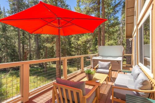 a patio with a red umbrella on a deck at Jester Court home in Tahoe Vista
