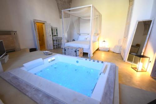 a large bath tub in a room with a bed at Palazzo Castriota in Alezio
