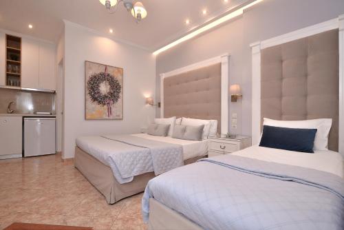 a hotel room with two beds and a kitchen at Epavlis Luxury apts in Leptokaria