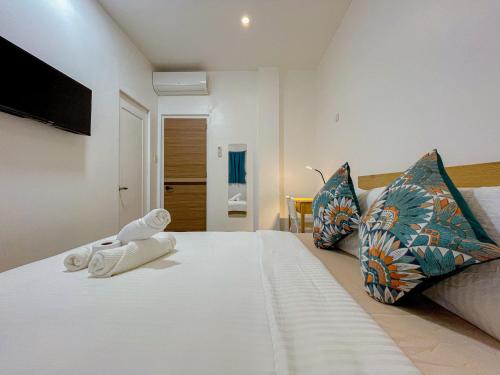 a bedroom with a large white bed with two pillows at Baydreams in Coron