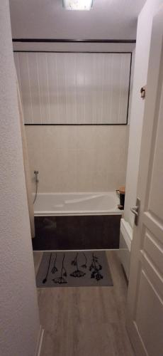 a bathroom with a bath tub and a bath rug at Appartement Villar d'arène in Villar-dʼArène