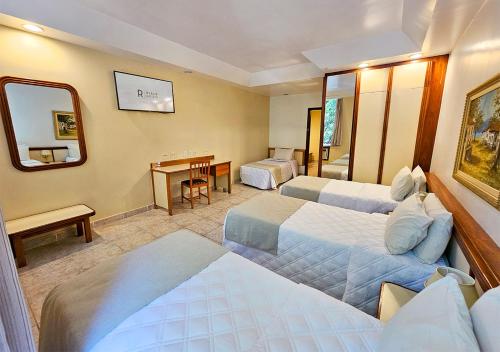 a hotel room with two beds and a desk at Riale Imperial Flamengo in Rio de Janeiro