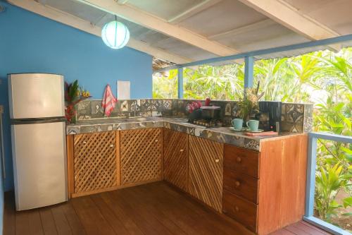 an outdoor kitchen with a counter and a refrigerator at Villas Itaita Beach Cabins in Punta Uva