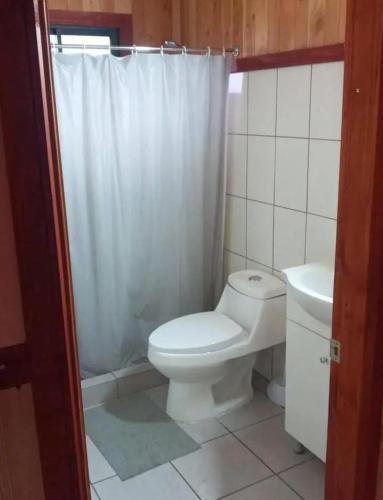 a bathroom with a white toilet and a sink at Descanso llafenco in Minetué