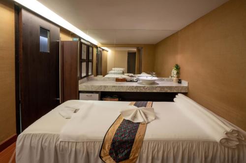 a bedroom with a bed with a tie on it at Garden Plaza Saigon - Formerly PARKROYAL Saigon in Ho Chi Minh City