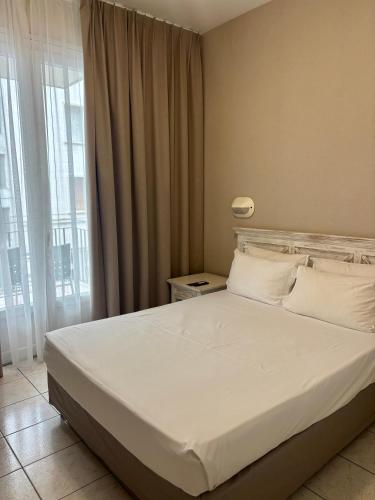 a bedroom with a large bed with white sheets and pillows at Maison Bonaparte in Bastia