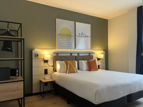 a bedroom with a large bed and two lamps at voco Bilbao - City by IHG in Bilbao