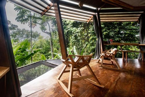 two chairs in a room with a view of the forest at La Loma Jungle Lodge and Chocolate Farm in Bocas del Toro
