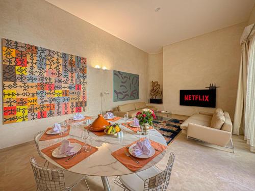 a living room with a table with chairs and a couch at Riad Timija in Marrakech