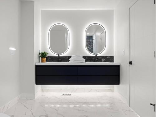 a bathroom with a black vanity and two mirrors at Modern Midtown in Yegen