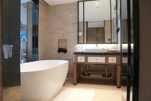 a bathroom with a large tub and a sink at 海丝博亚国际酒店会议中心 in Donghai