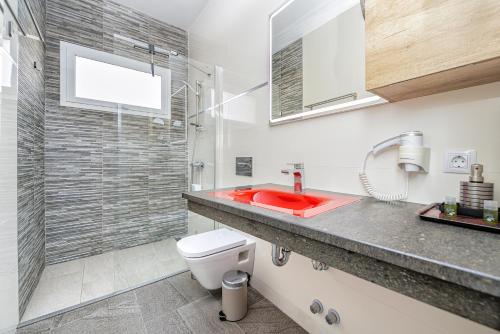 a bathroom with a red sink and a shower at VillasRoyale Trespalomas - An Iconic Villa for Elevated Getaways! in Meloneras