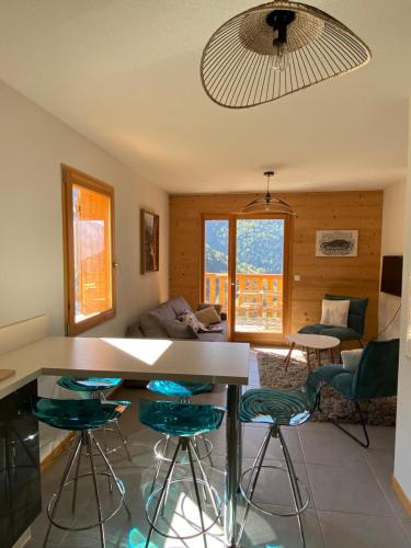ein Wohnzimmer mit einem Tisch und einigen Stühlen in der Unterkunft La Tanière in Vaujany
