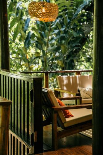 a porch with a chair and a chandelier at La Loma Jungle Lodge and Chocolate Farm in Bocas del Toro