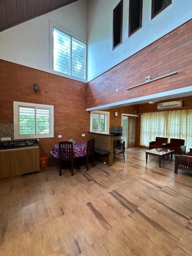 a large living room with a table and chairs at Cottage on Riverside in Irinjālakuda