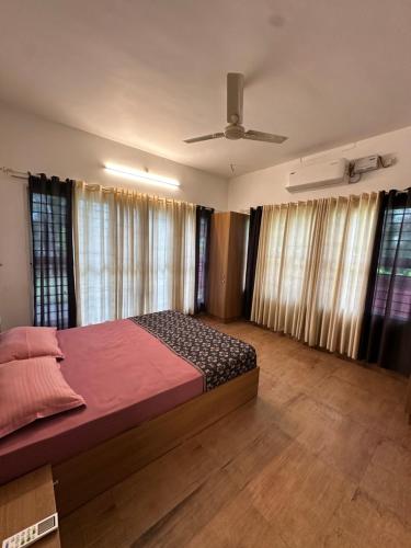 a bedroom with a bed and a ceiling fan at Cottage on Riverside in Irinjālakuda