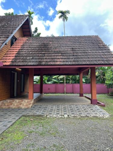 a pavilion with a roof on top of a building at Cottage on Riverside in Irinjālakuda