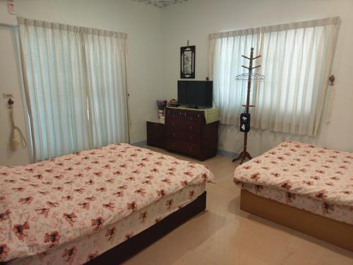 a bedroom with two beds and a television in it at Harmony Village in Wujie
