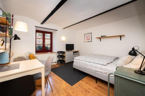 a living room with a bed and a desk at Bedřichov U Nás in Bedřichov
