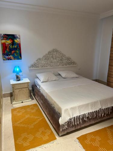 a bedroom with a bed and a table with a lamp at Dar El Noor in Yasmine