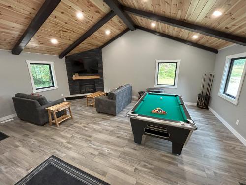 a living room with a pool table in it at The Farmhouse at Rustic Ridge in Benzonia