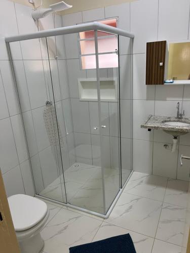 a bathroom with a shower with a toilet and a sink at Chácara Barone - Chácara em SerraNegra in Serra Negra