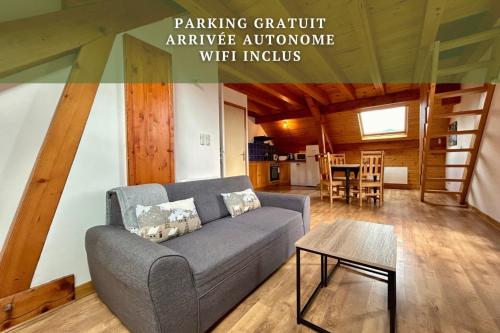 a living room with a couch and a table at Chez Fred 202 - Parking Wifi Balcon in Saint-Pierre-dʼAlbigny