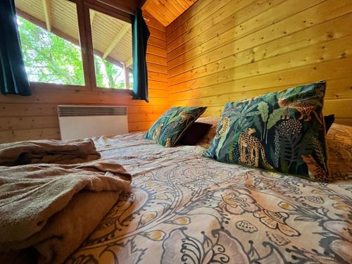 Cama o camas de una habitación en Cabane Dans Les Arbres Avec Bain Nordique