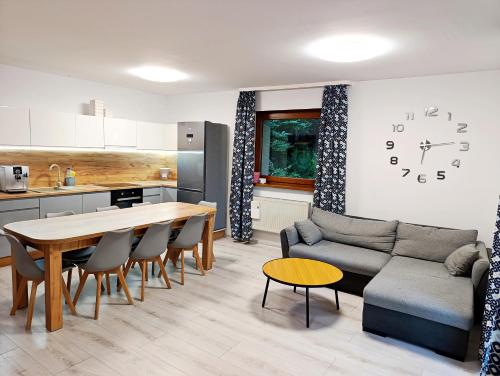 a kitchen and living room with a table and a couch at Furtka do Lasu in Szklarska Poręba