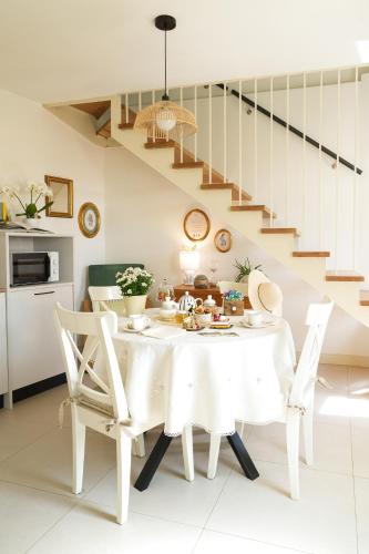 a white dining room with a white table and chairs at Casa Paola in Borso del Grappa